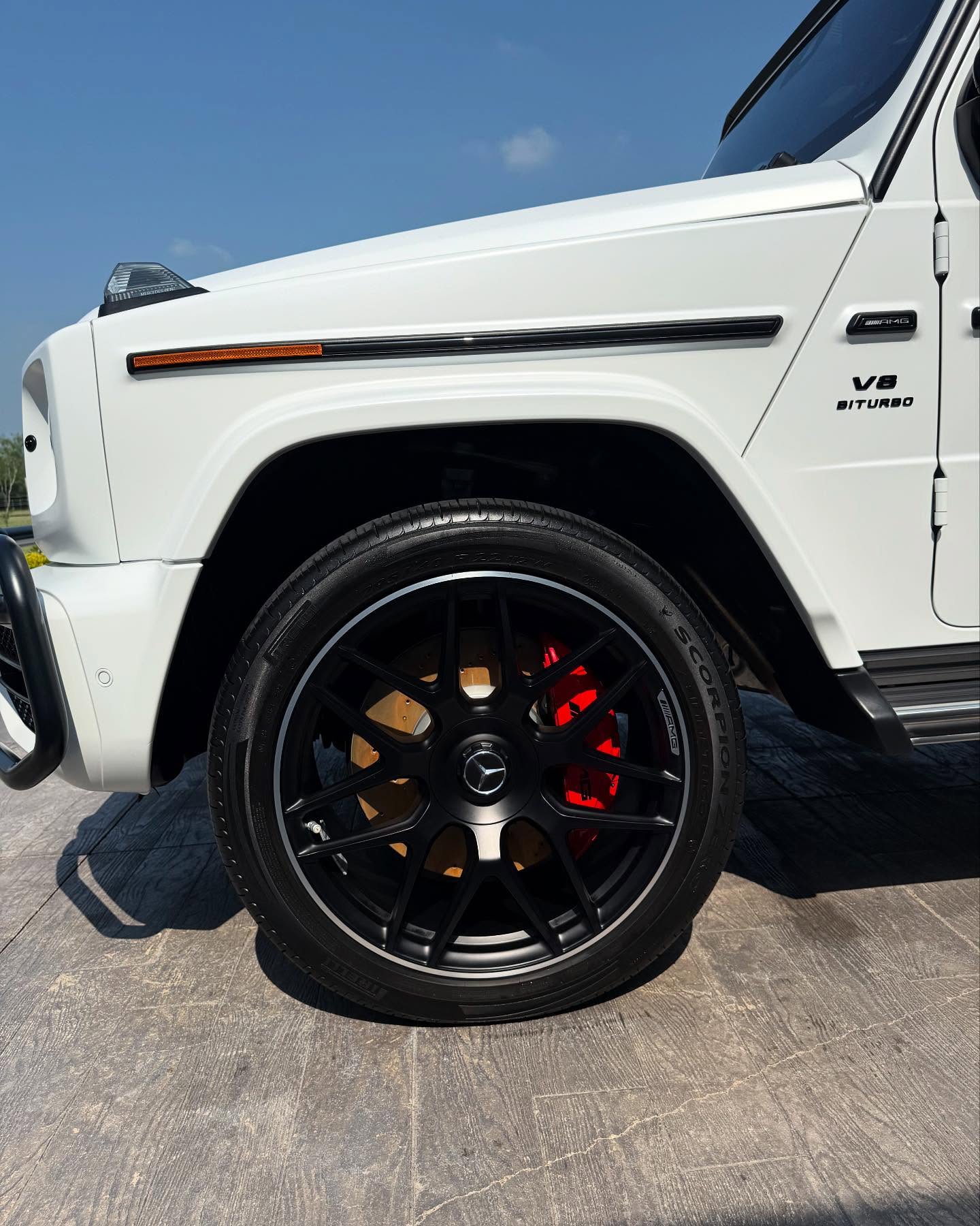 Close-up of a white Mercedes-AMG fender and polished wheel with a smooth, reflective exterior finish by I Auto Detailing in McAllen, TX