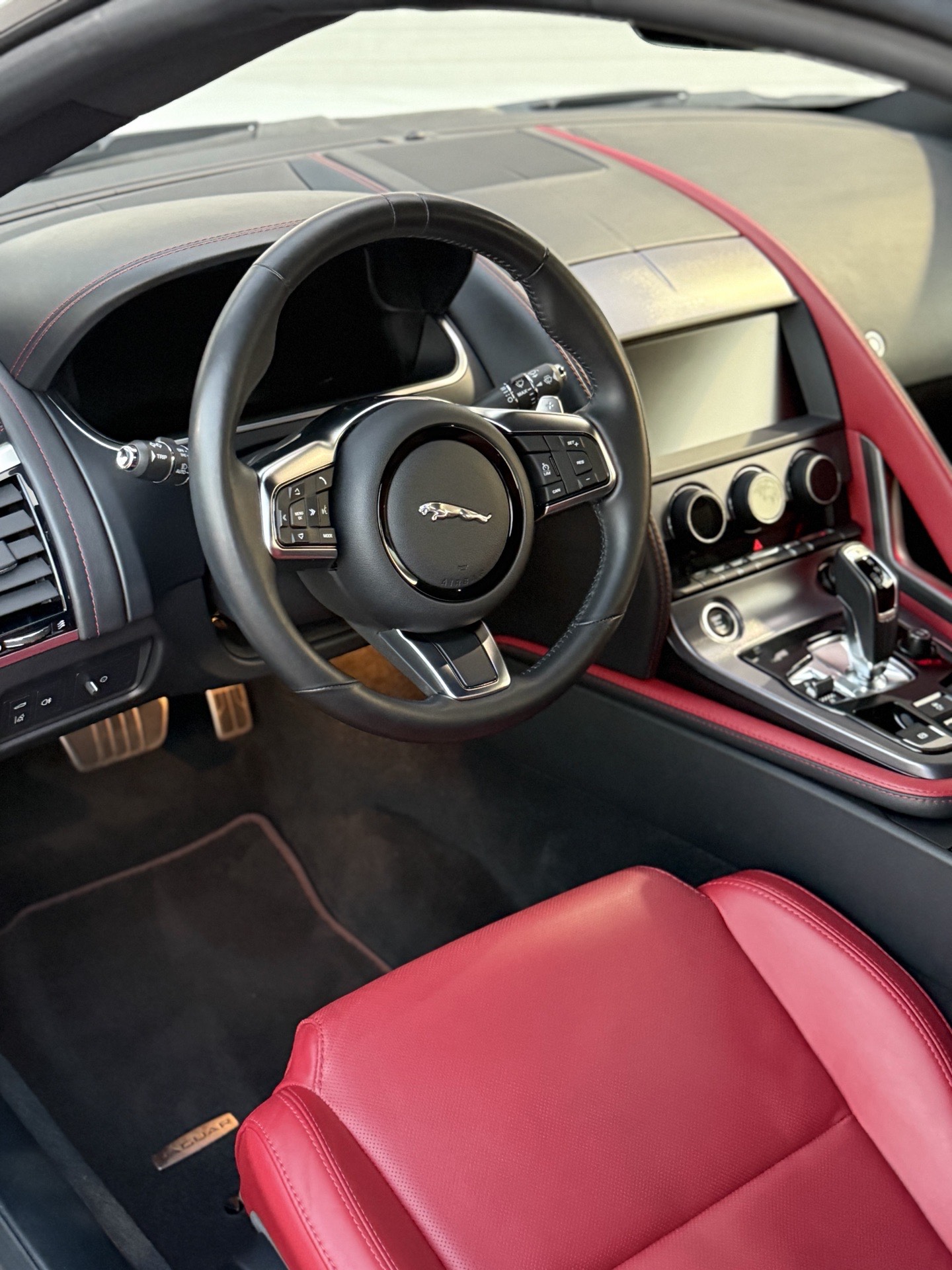 Spotless red-and-black sports car interior with freshly cleaned leather and carpets by I Auto Detailing in McAllen, TX