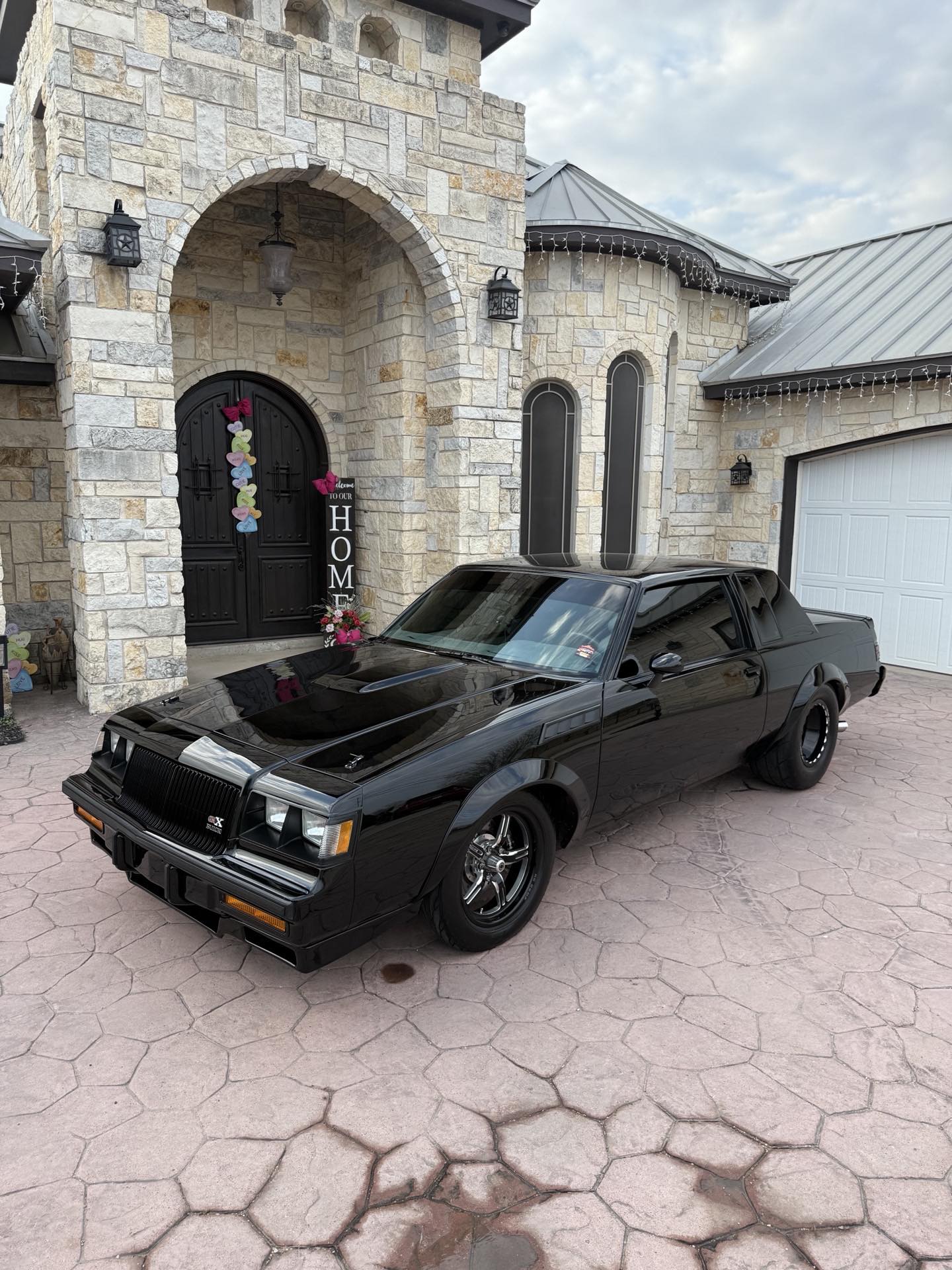 Glossy black Buick with a deep, mirror-like ceramic-coated finish in a home driveway by I Auto Detailing in McAllen, TX