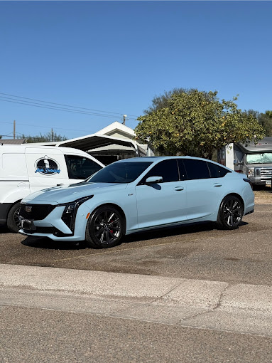 Ice-blue Cadillac CT5-V sedan detailed to a glossy finish with the I Auto Detailing mobile van behind it in Palmview, TX